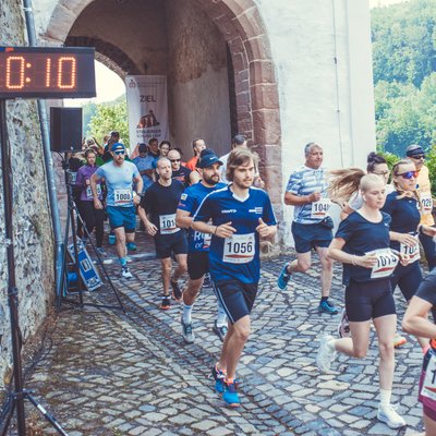 10 km Laufen Läuferfeld passiert das Schlosstor mit Zeitmessung beim Stolberger Schloss-Lauf.